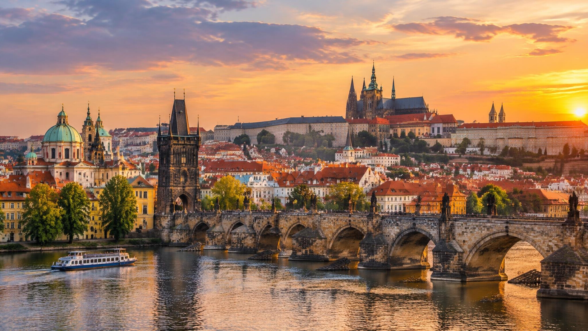 Prague old town rooftops and bridge at golden hour